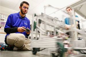 Cavelero Mid High junior Kashan Hussain tests a remote space vehicle, which speeds forward, after he built and programmed it with his work partner Tyler Koon (right) Thursday in a computer lab attached to a large assembly facility where the schools robotics club meets and works. Kashan is one of 25 student ambassadors chosen for the national program Back to Space. (Dan Bates / The Herald)