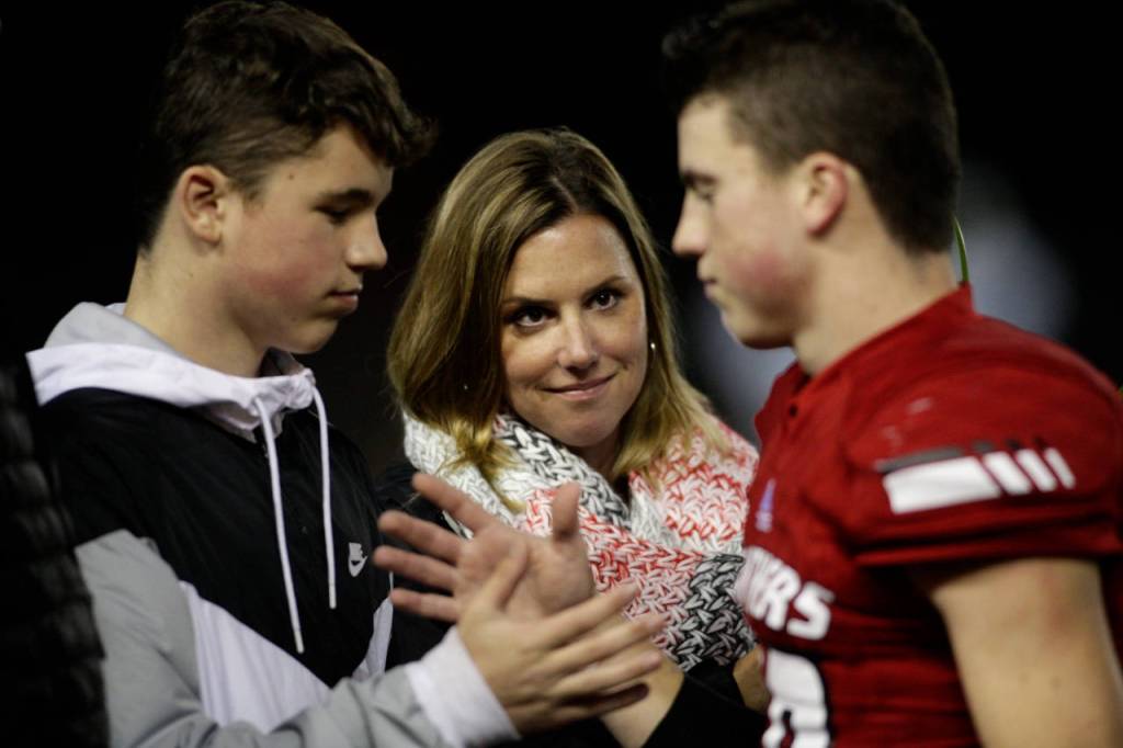 Snohomishs Langdon Orgill (right) shakes hands as senior players and their families are introduced before the Panthers beat Squalicum 30-27 Fridayat Veterans Memorial Stadium in Snohomish. (Andy Bronson / The Herald)