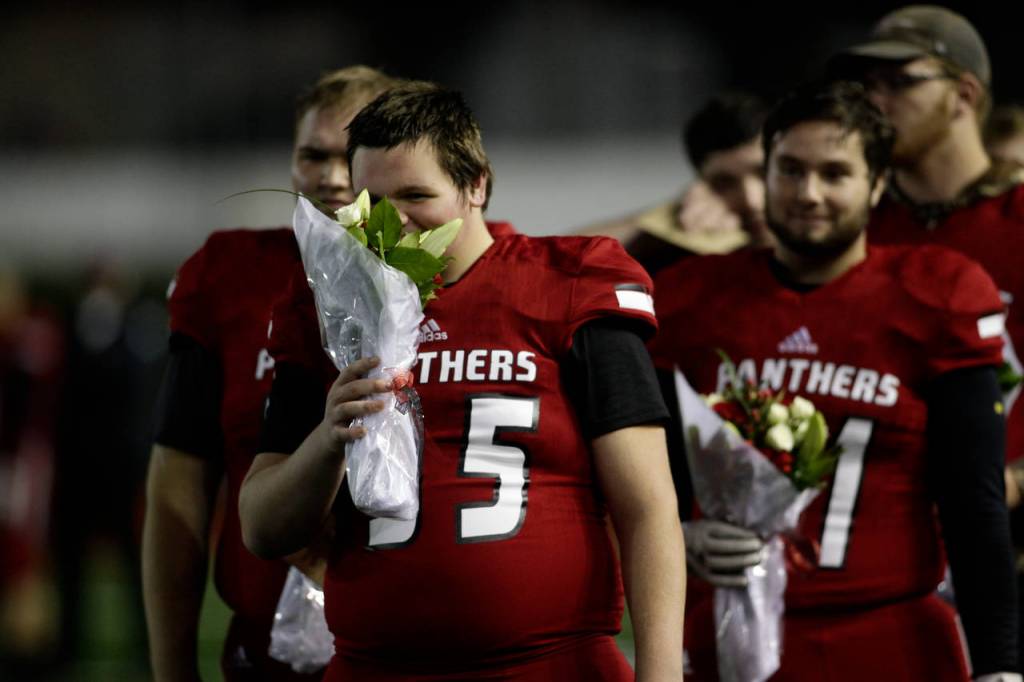 Snohomishs Noah Dunham smells flowers before Senior Night festivities Fridayat Veterans Memorial Stadium in Snohomish. Snohomish beat Squalicum 30-27. (Andy Bronson / The Herald)