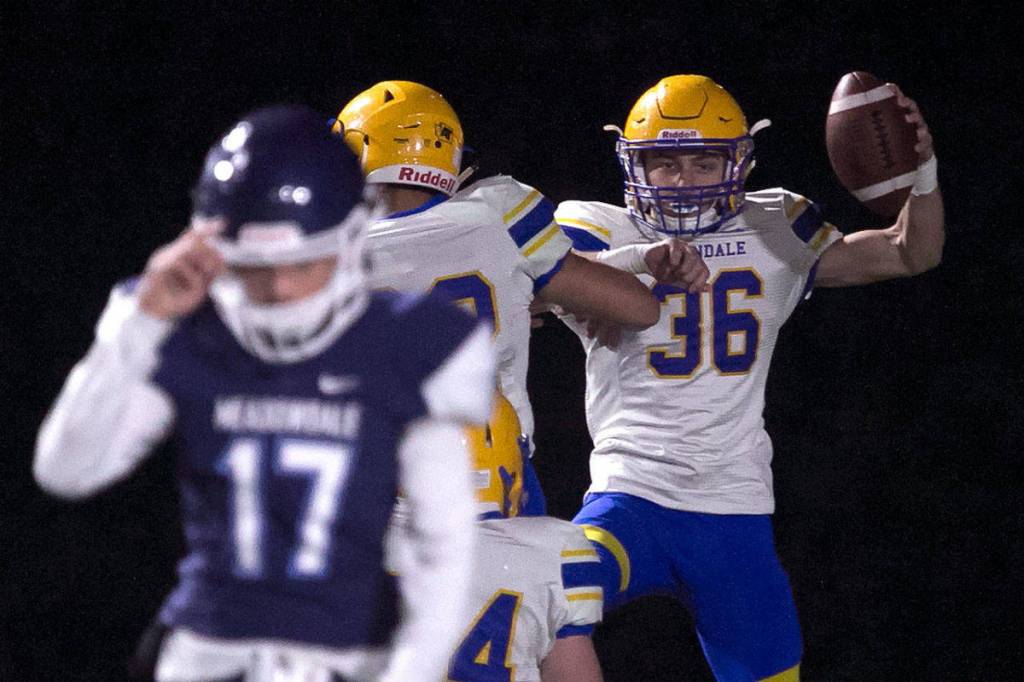 Ferndales Jaden Brown (right) celebrates his fumble-return touchdown during a loser-out Wesco 3A crossover game against Meadowdale on Friday night at Edmonds Stadium. The Golden Eagles eliminated the Mavericks with a 56-15 win. (Kevin Clark / The Herald)