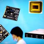 A visitor walks past a display showing microchips and circuit boards in May, during the 21st China Beijing International High-Tech Expo in Beijing. (Mark Schiefelbein / Associated Press)