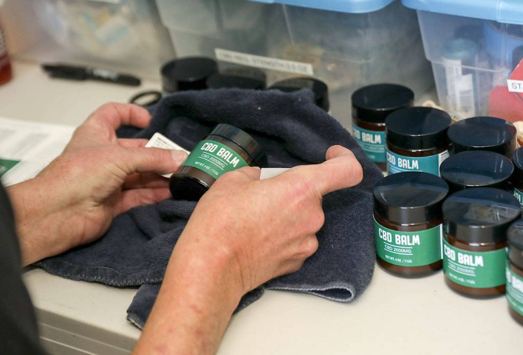 Ron Gordon puts the finishing touches on the CBD balm that he makes at the Snohomish Senior Center. (Lizz Giordano / The Herald)