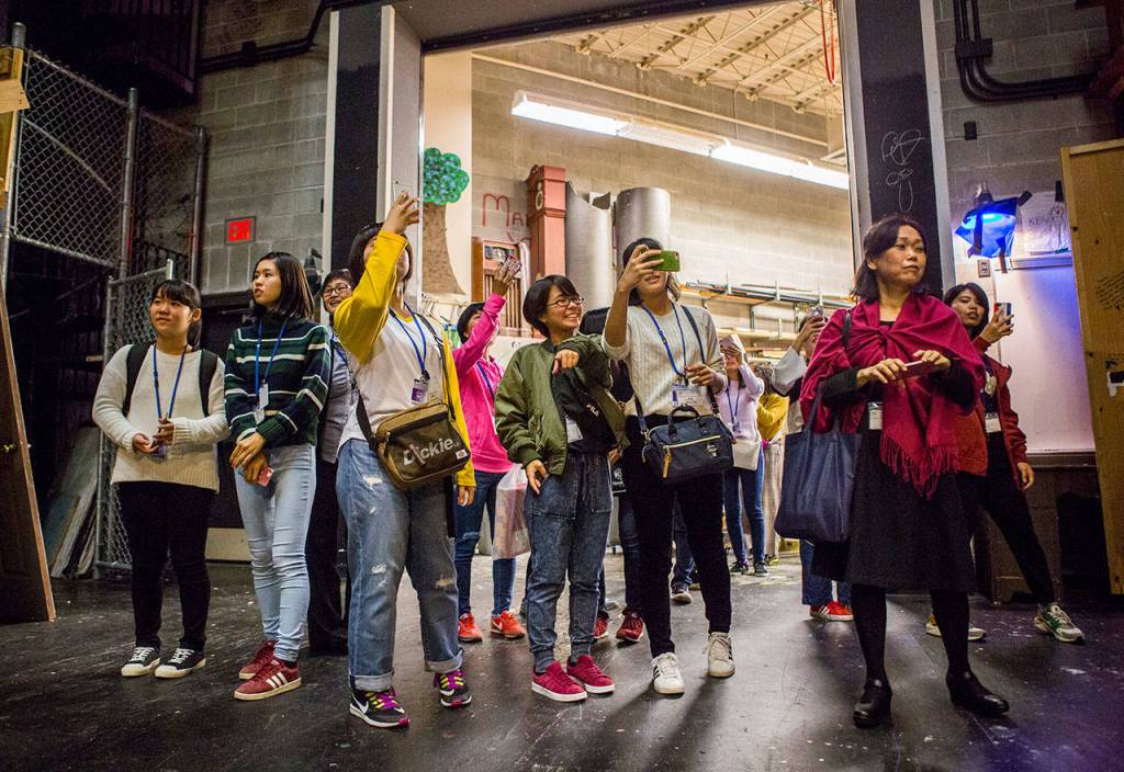 Japanese students and teachers take pictures of the school theater during their tour of Kamiak High School. (Olivia Vanni / The Herald)