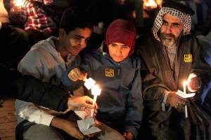 Muhammad Al-ali (left to right) Bentalha Al-Ali and Lafti Al-Ali work to light their candles during the interfaith candlelight vigil Thursday night on November 1, 2018. (Kevin Clark / The Herald)