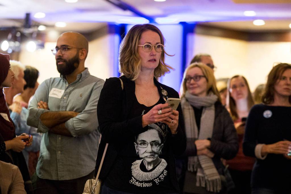 Laura Taylor sports a Notorious RBG shirt as she watches the election returns at the Washington State Democratic Partys 2018 Election Night Watch Party at the Bellevue Hilton on Tuesday. (Andy Bronson / The Herald)                                Laura Taylor watches the election returns at the Washington State Democratic Partys election night party at the Bellevue Hilton on Tuesday. (Andy Bronson / The Herald)