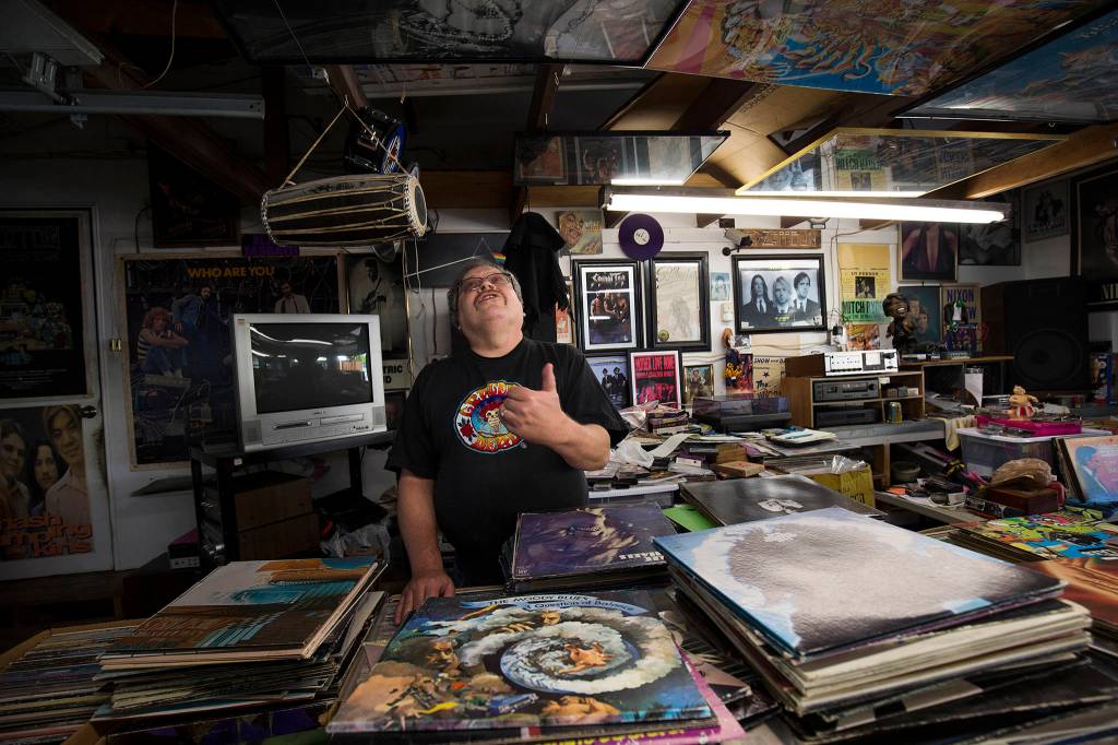 Kevin Grigsby, 61, looks at posters on the ceiling above the 100,000 record albums he sells from his Lynnwood garage on Sept. 28 in Lynnwood. (Andy Bronson / The Herald)