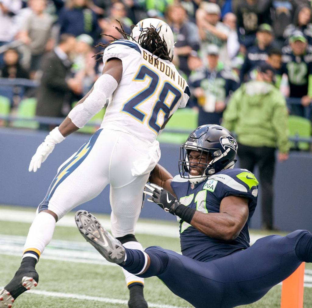 Chargers running back Melvin Gordon III crosses the goal line with Seahawks linebacker Barkevious Mingo trailing Sunday afternoon at CenturyLink Field in Seattle on November 4, 2018. Chargers won 25-17. (Kevin Clark / The Herald)
