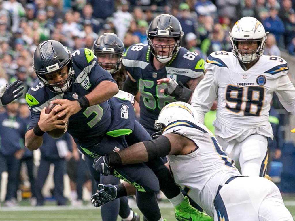 Seahawks quarterback Russell Wilson is tackled by Chargers defensive lineman Brandon Mebane Sunday afternoon at CenturyLink Field in Seattle on November 4, 2018. Chargers won 25-17. (Kevin Clark / The Herald)