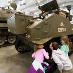 Eli Spaun, 5, Vin Capelli, 7, and Zoe Spaun, 7, right, peer at the underside of a M5A1 Stuart Light Tank in the new 30,000-square-foot hangar at the Flying Heritage & Combat Armor Museum at Paine Field on Saturday, Nov. 10, 2018 in Everett, Wa. The new hangar allows visitors a closer and touchable engagement with the museums armored vehicles. (Andy Bronson / The Herald)