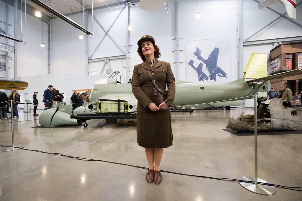Marie Samson, of Redmond, poses for pictures in her World War II uniform in front of a Junkers Ju-87 Stuka in the new 30,000 foot hangar at the Flying Heritage & Combat Armor Museum at Paine Field on Saturday, Nov. 10, 2018 in Everett, Wa. (Andy Bronson / The Herald)