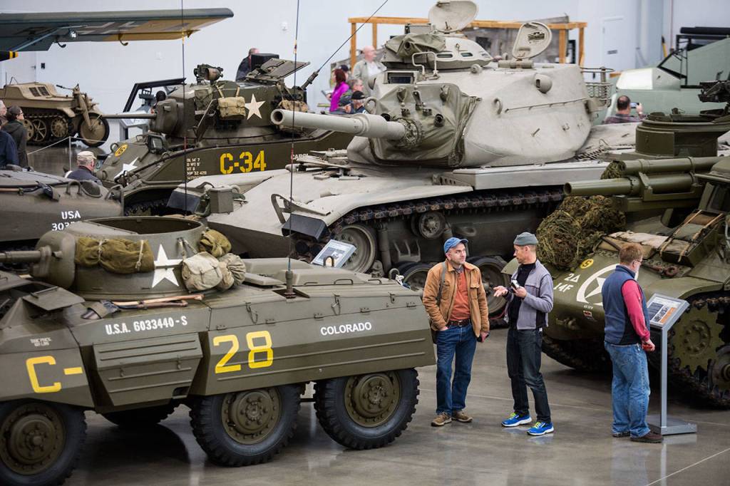 Visitors talk between a half-dozen tanks in the new hangar at the Flying Heritage & Combat Armor Museum at Paine Field on Saturday, Nov. 10, 2018 in Everett. (Andy Bronson / The Herald)