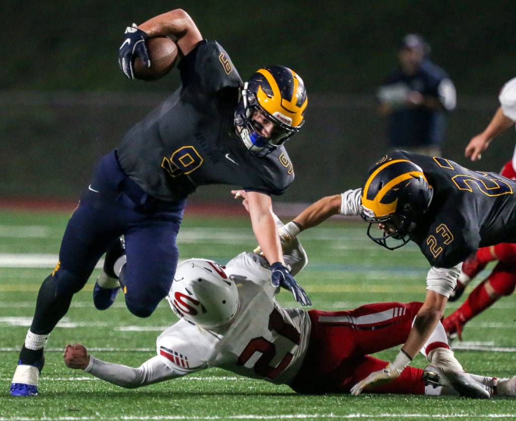 Bellevues Jody Schneider slips a tackle by Snohomishs Tyler Massena with Bellevues K.J. Wright (right) trailing Friday in Bellevue. (Kevin Clark / The Herald)
