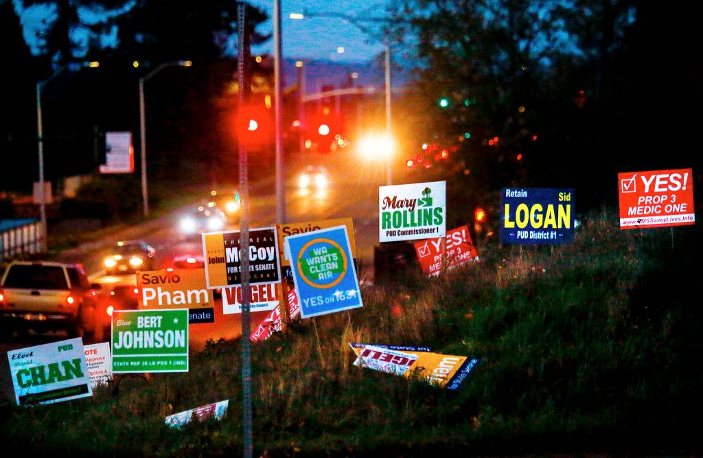Afternoon commuters encounter more than 16 political signs on the northeast corner of Colby Avenue and 44th Street in Everett. (Dan Bates / The Herald)