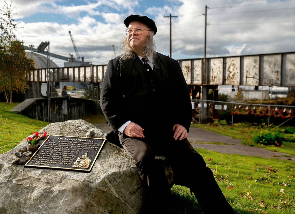 Seated next to the Everett Massacre plaque and dressed with a vintage look, history buff Christopher Summit talks about the events that took place Nov. 5, 1916, from a little different perspective. (Dan Bates / The Herald)