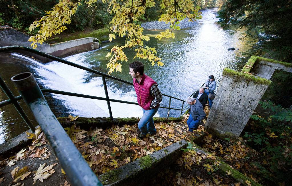 Tulalip Tribes Restoration Ecologist Brett Shattuck, in red vest, takes a tour up the steps of the Pilchuck Dam along the Pilchuck River on Oct. 16 in Granite Falls. A joint project by the Tribes and Snohomish County intends to remove the dam by the fall of 2020. (Andy Bronson / The Herald)