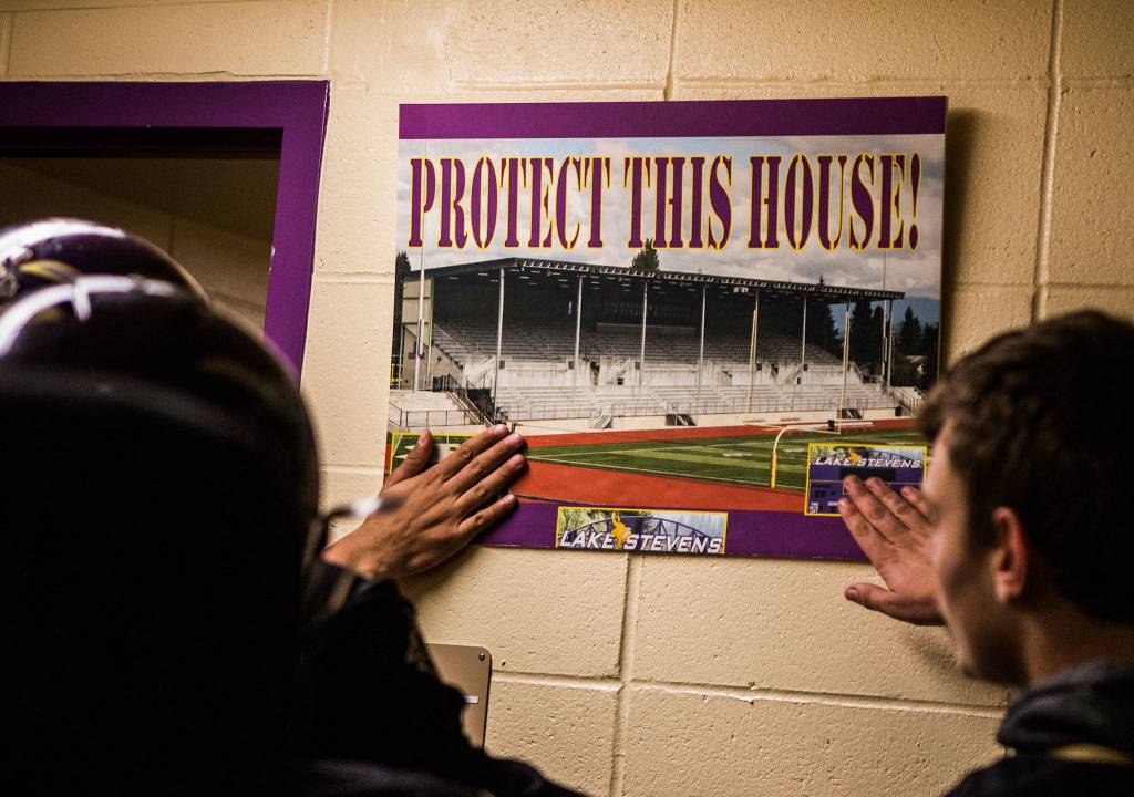 Lake Stevens players touch a sign that says. Protect this house! before the game against Graham Kapowsin on Saturday, Nov. 17, 2018 in Lake Stevens, Wa. (Olivia Vanni / The Herald)