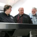Kathy Taylor, a forensic anthropologist with the King County Medical Examiners Office, left, detective Jim Scharf of the Snohomish County Sheriffs Office, center, and mental health professional Chuck Wright look over bones on a table Nov. 13 at the Snohomish County Medical Examiners Office. (Kevin Clark / The Herald)