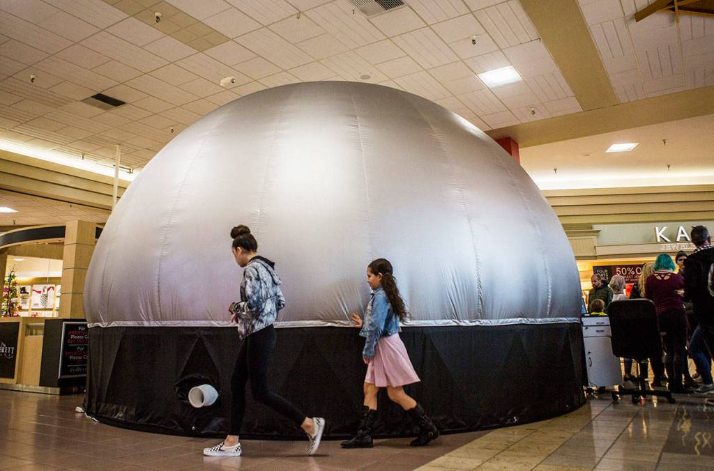 People walk by and touch the Planetarium 360 at the Everett Mall on Saturday. (Olivia Vanni / The Herald)