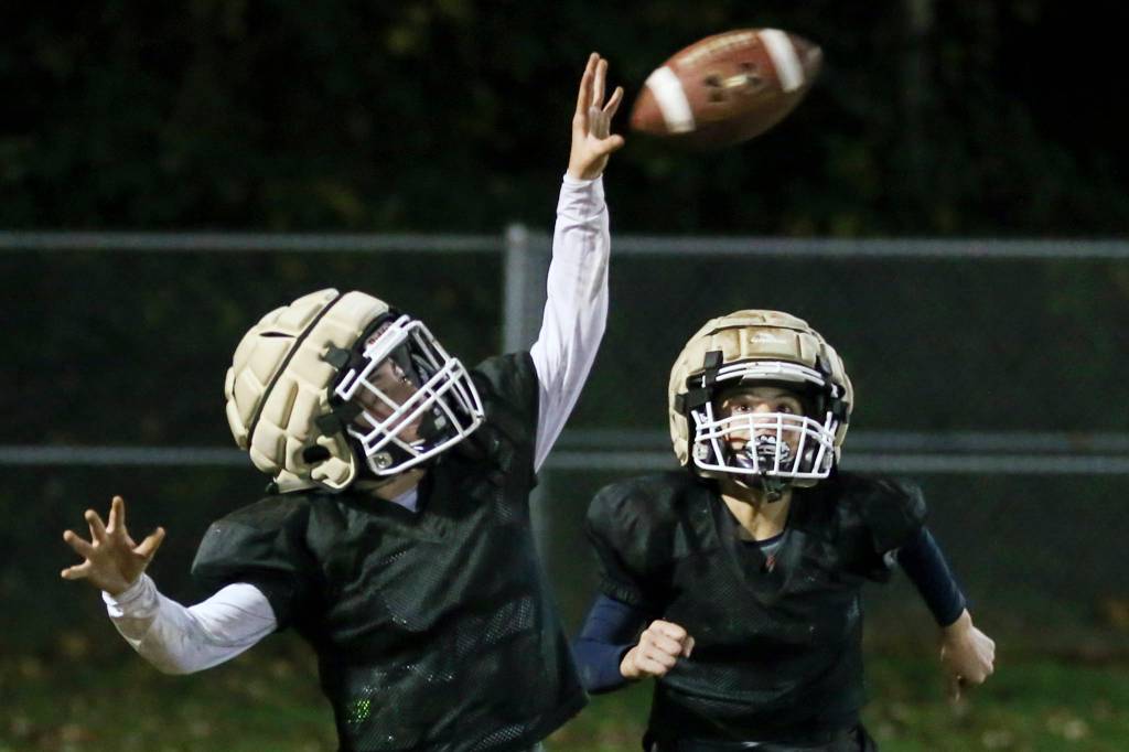 Connor Geary attempts a catch with Kaiden Duong trailing during practice at the Lake Stevens Boys and Girls Club on Nov. 15. (Kevin Clark / The Herald)