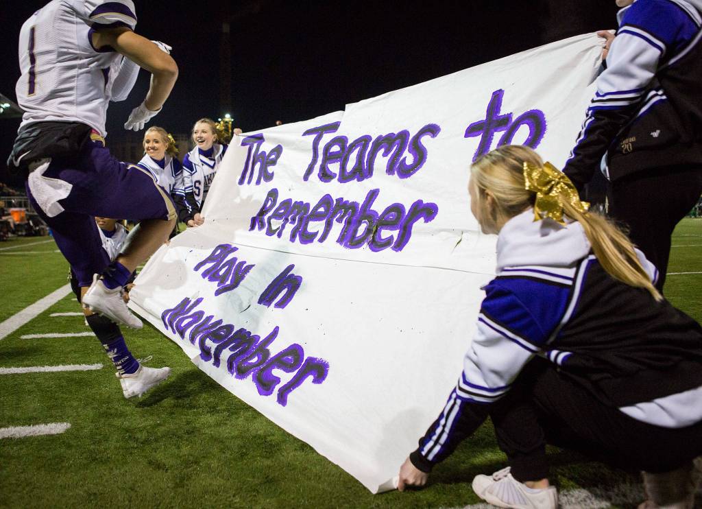 The Lake Stevens Cheer team holds a banner for the team as they run onto the field after halftime during the Class 4A state state semifinal game against Woodinville at Pop Keeney Stadium on Saturday, Nov. 24, 2018 in Bothell, Wa. (Olivia Vanni / The Herald)