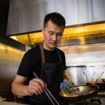 Capers + Olives chef and owner Jimmy Liang places sage leaves on agnolotti pasta in the kitchen of his Everett restaurant. (Olivia Vanni / The Herald)