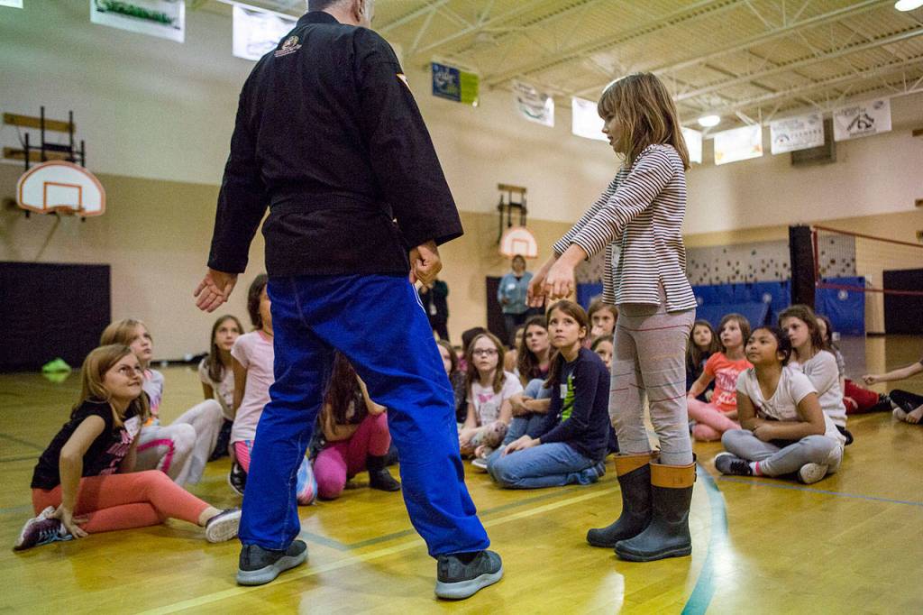 Girls watch as they are taught defense moves during an InspireHER event at the Snohomish Boys & Girls Club. (Olivia Vanni / The Herald)