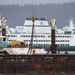 A worker directs others on a barge during construction Feb. 28 at the new Mukilteo ferry dock. Washington State Ferries awarded a $49.7 million contract to begin work on the passenger building, holding lanes, toll plaza and waterfront promenade. (Andy Bronson / Herald file)