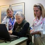 Cathy Fliris (left), Colleen Shannon (center) and Kathryn Arneson look over test results of a patient at the Safe Harbor Clinic in Stanwood. (Olivia Vanni / The Herald)