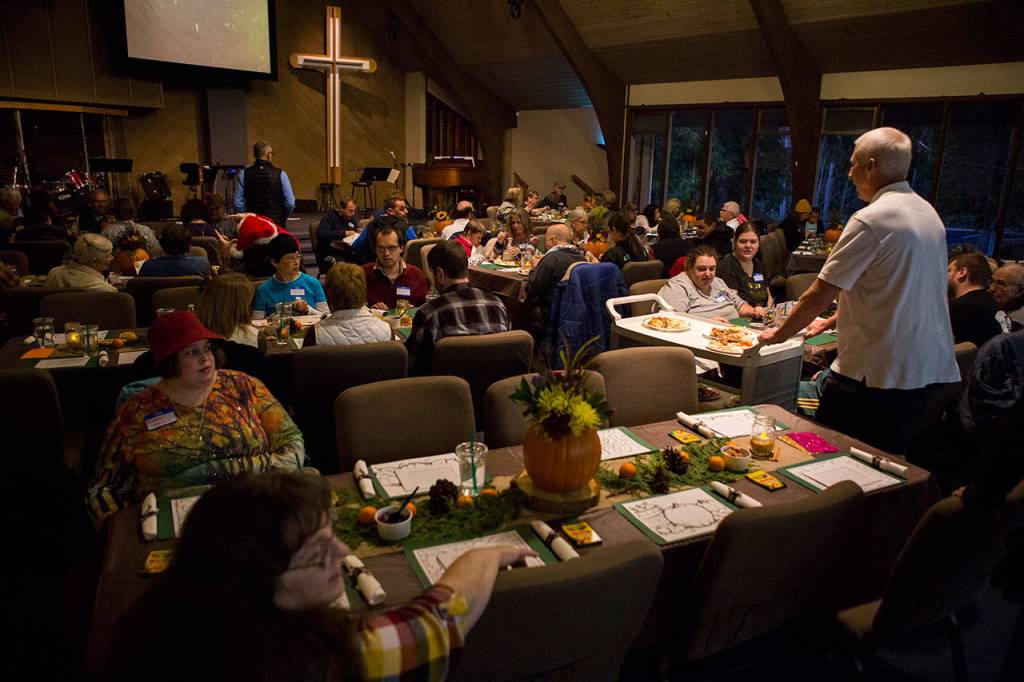 Volunteers serve dinner during the Eagle Wings disAbility Ministries Thanksgiving celebration at Warm Beach Free Methodist Church in Stanwood. (Olivia Vanni / The Herald)