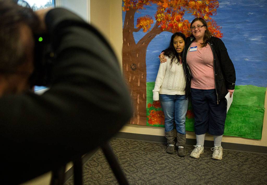 Cece Jimenez (left) and Brittany Smolinski pose for a photo during the Eagle Wings disAbility Ministries Thanksgiving dinner at Warm Beach Free Methodist Church in Stanwood. (Olivia Vanni / The Herald)