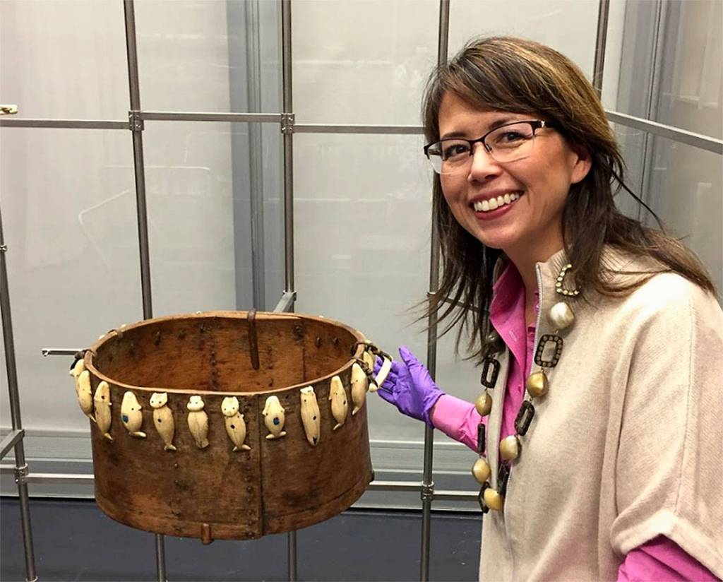 Everett artist Susan Ringstad Emery with an artifact from the Smithsonian collection at the Anchorage Museum. Items are tethered to movable metal racks to protect them from earthquake damage.