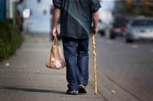 A man carries items in a plastic bag as he walks down Evergreen Way on Thursday, Oct. 11, 2018 in Everett, Wa. The city of Everett is looking at a ban on the bags. (Andy Bronson / The Herald)