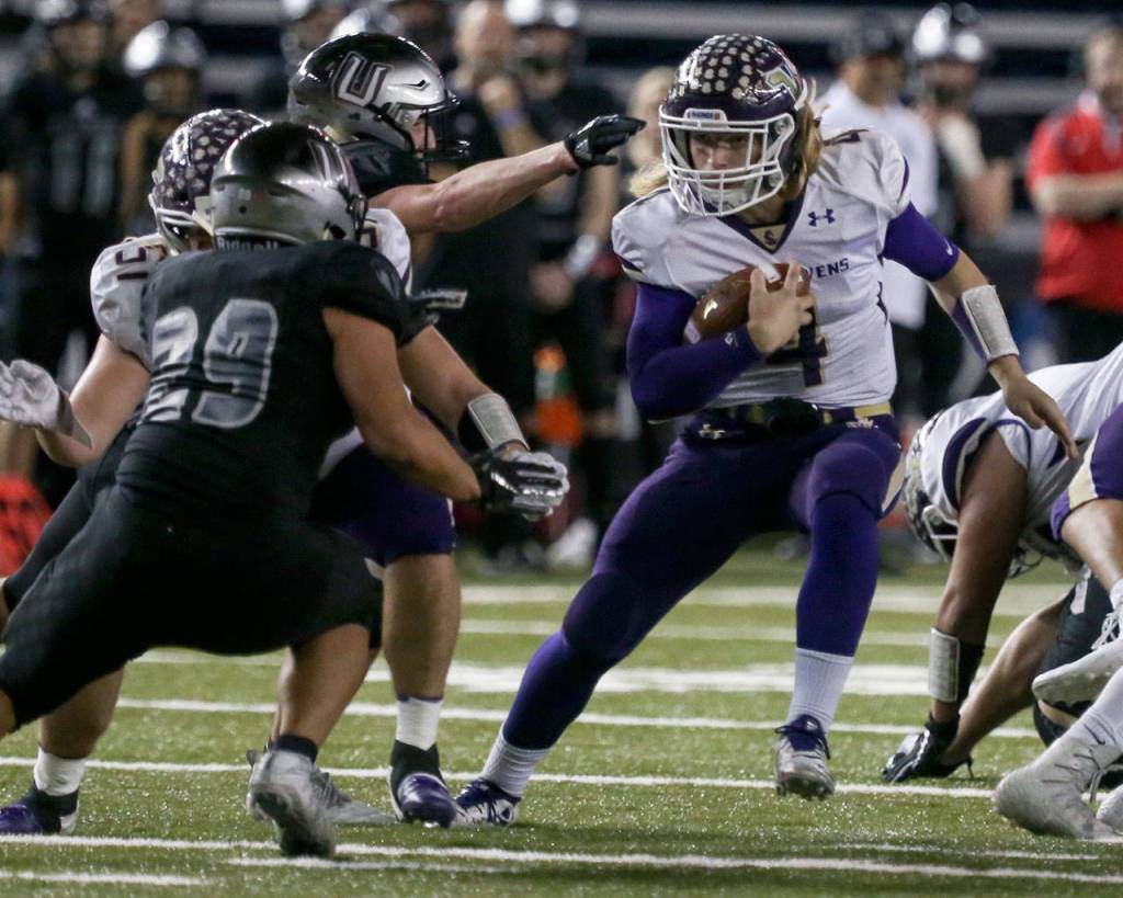 Lake Stevens Tre Long rushes with Union defenders closing during the 4A state football championship game on Dec. 1, 2018, at the Tacoma Dome. (Kevin Clark / The Herald)