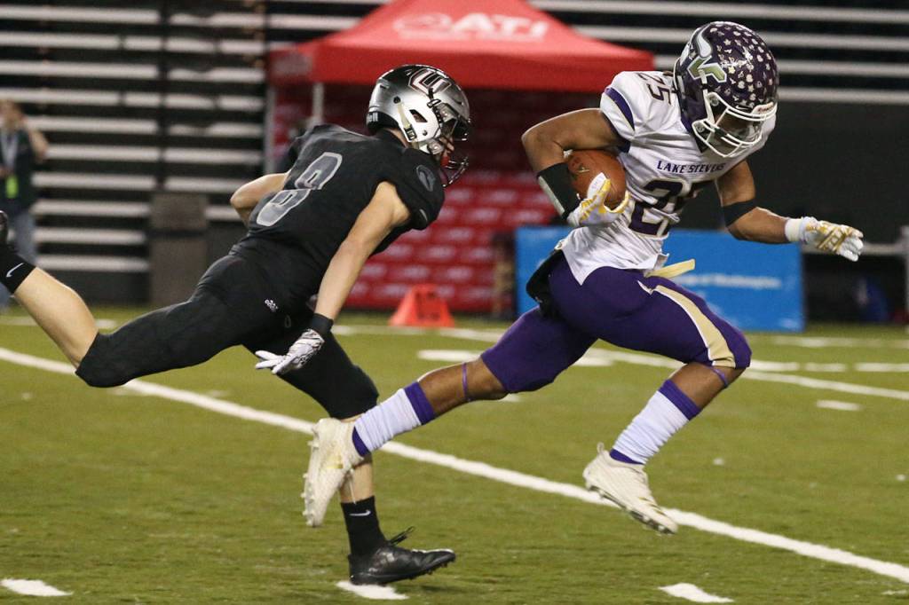 Lake Stevens Kasen Kinchen (right) runs after a reception with Unions Daron Ulrich closing during the 4A state football championship game on Dec. 1, 2018, at the Tacoma Dome. (Kevin Clark / The Herald)