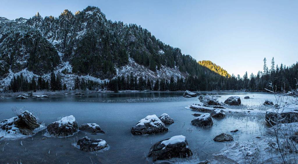 Snow and a solid layout of ice cover the banks of Heather Lake on Wednesday, Dec. 5, 2018 in Granite Falls, Wa. (Olivia Vanni / The Herald)