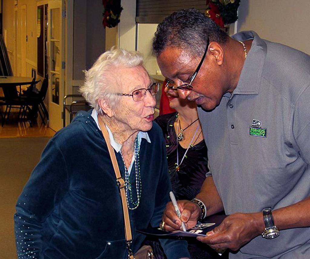 Fred Anderson, a former Seahawk, assists one of many appreciative seniors during a 12 Days of Goodness event. (Contributed Photo)