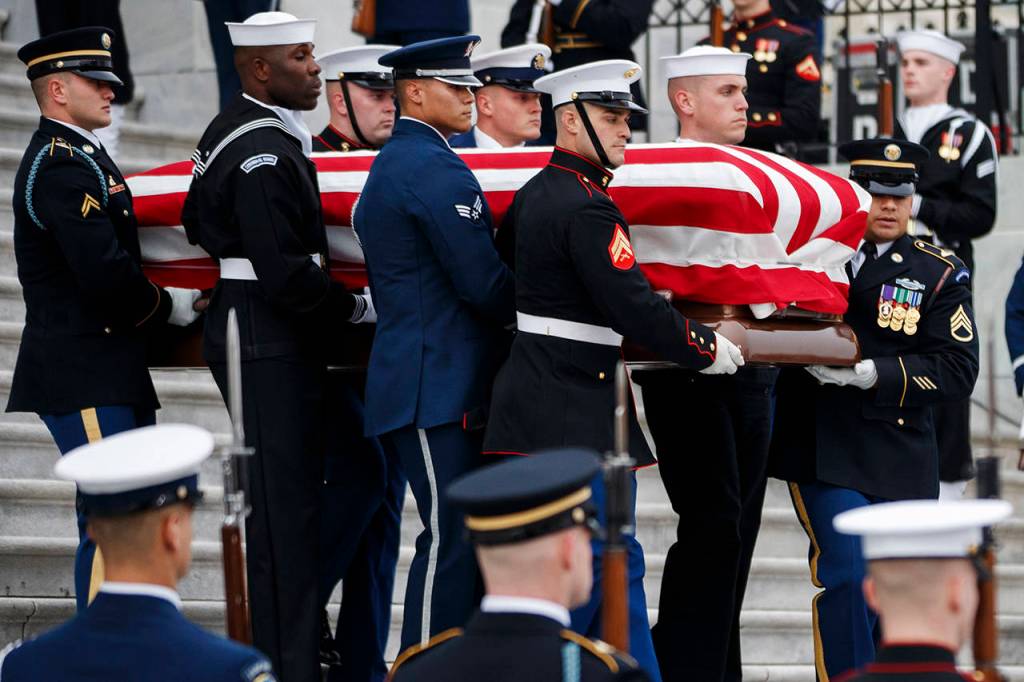 The flag-draped casket of former President George H.W. Bush is carried by a joint services military honor guard from the U.S. Capitol on Wednesday in Washington. (Shawn Thew/Pool Photo via AP)