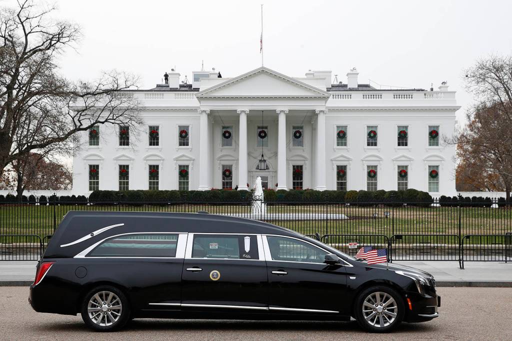 The hearse carrying the flag-draped casket of former President George H.W. Bush passes by the White House from the Capitol, heading to a State Funeral at the National Cathedral on Wednesday in Washington. AP Photo/Jacquelyn Martin)