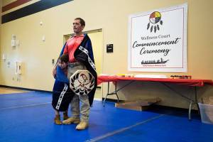 At the Don Hatch Youth Center, Verle Smith starts to tear up while friends and family congratulate him as the first graduate from the Tulalip Healing to Wellness Court, on Monday, Dec. 10, 2018 in Tulalip Reservation, Wa. His daughter Melody, 5, hides under a blanket, presented to him for graduating the program. (Andy Bronson / The Herald)