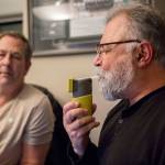 Lynnwood police officer Mark Brinkman watches as Maury Eskenazi blows into a breath test at the KRKO radio office in Everett. (Olivia Vanni / The Herald)