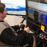 North Creek High School junior Austin Mitchell learns to fly using a $14,000 Redbird flight simulator in Northshore School Districts new Introduction to Aviation class. (Northshore School District)