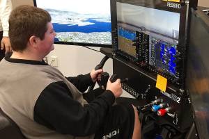 North Creek High School junior Austin Mitchell learns to fly using a $14,000 Redbird flight simulator in Northshore School Districts new Introduction to Aviation class. (Northshore School District)