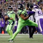 Seahawks quarterback Russell Wilson (left) looks for room to pass as Jordan Simmons (66) blocks the Vikings Linval Joseph in the first half of a game on Dec. 10, 2018, in Seattle. (AP Photo/Ted S. Warren)