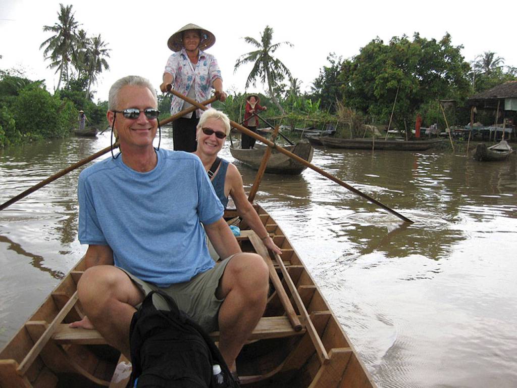 Petra Rousu and her husband, Don, ride in a long boat on the Mekong Delta in Vietnam. (Petra Rousu)