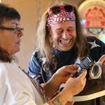Teri Banks (left) looks at a pair of sneakers with bluetooth speakers in the soles as Wade Tucker laughs on Saturday, Dec. 15, at Twin Foxes in Everett. (Kevin Clark / The Herald)
