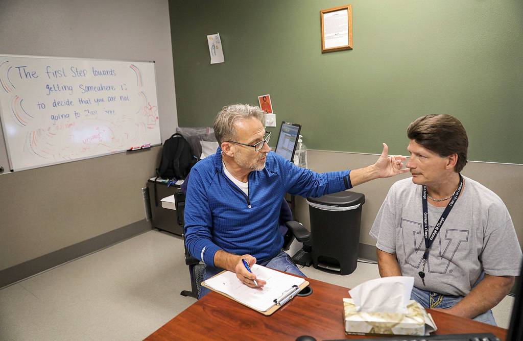 Geoffrey Godfrey (left), a nurse practitioner at Ideal Option, counsels Curtis Letzkus, who was connected to the addiction medicine clinic through the Snohomish County Jail. (Lizz Giordano / The Herald)