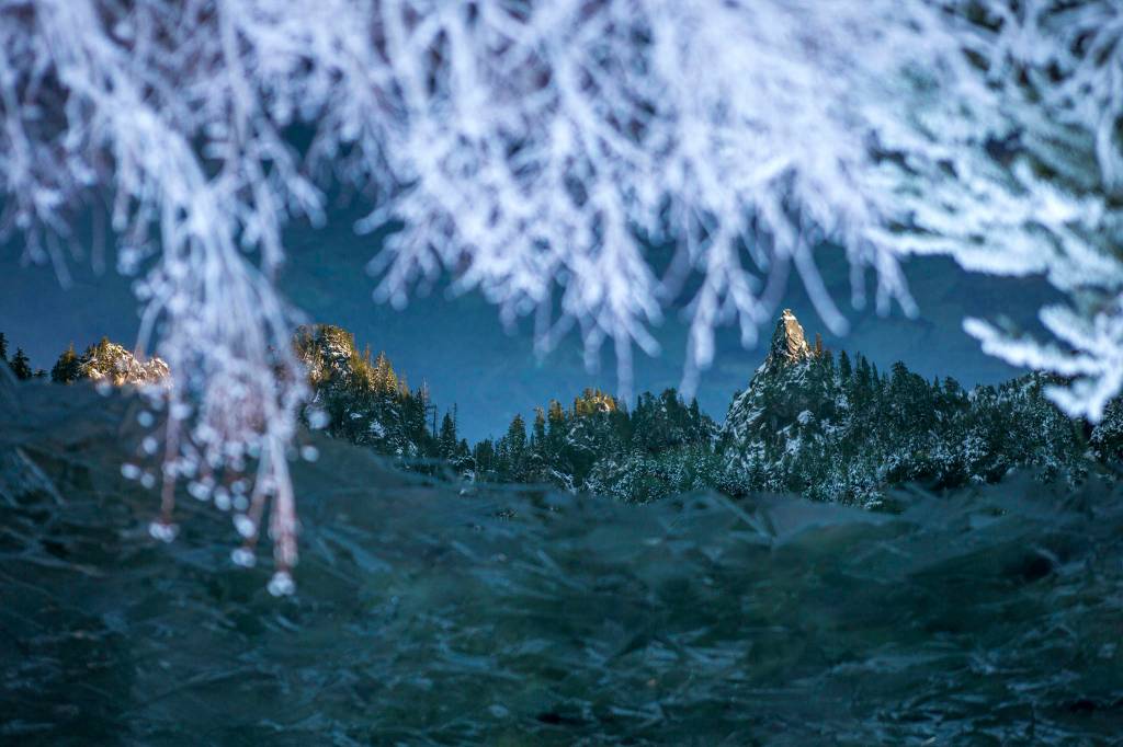 Mountain peaks surrounding <a href="https://www.heraldnet.com/life/snow-searching-hikes-for-when-you-want-to-see-the-white-stuff/" target="_blank">Heather Lake</a> are reflected in the water Dec. 5 in Granite Falls. (Olivia Vanni / The Herald)