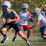 Maake Fifita (left) blocks with Ayden Ziomas handing off to Corbin Ferrie Thursday afternoon during practice Oct. 4, at Glacier Peak High School in Snohomish. (Kevin Clark / The Herald)