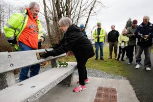After laying down flowers, Ann ODonnell touches a plaque with her late husband Dans name on it as family members and riders from The Big Shots Bicycle Group pay their respects at a bench in founder Dan ODonnells name along the Centennial Trail on Wednesday, Dec. 19, 2018 in Arlington, Wa. (Andy Bronson / The Herald)