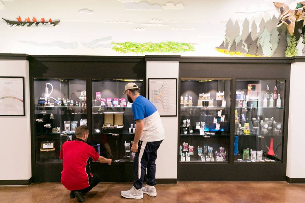 Carmen Miller (left) helps Ezekiel Eagle with his selection at Tulalip Remedy on Aug. 22. (Kevin Clark / Herald file)